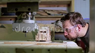 一个木匠正在测量一个木制卡车模型的标尺